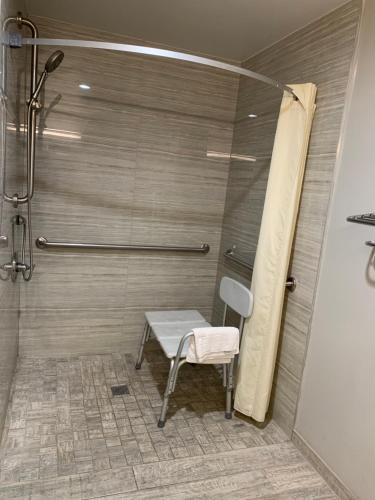 a shower with a bench in a bathroom at Buena Park Inn in Anaheim