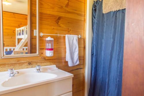 La salle de bains est pourvue d'un lavabo et d'un miroir. dans l'établissement JunoHall Backpackers, à Grottes de Waitomo