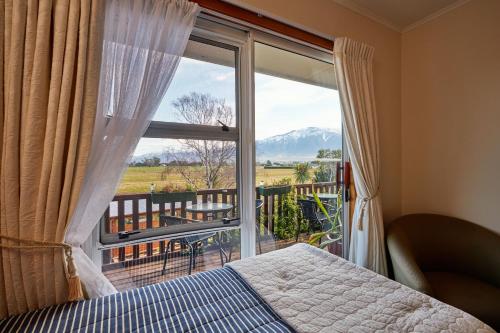 a bedroom with a bed and a window with a view at Brook House B&B & Cottages in Kaikoura