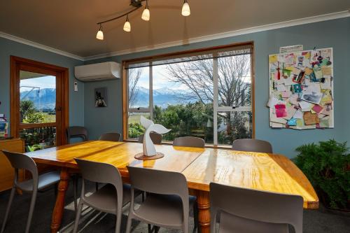 a dining room with a wooden table and chairs at Brook House B&B & Cottages in Kaikoura