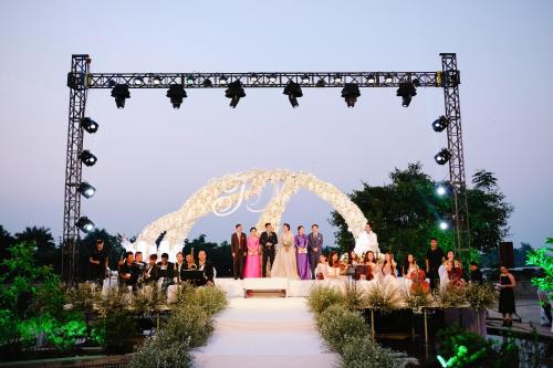 a group of people standing under an arch at a wedding at Sai Gon Dong Ha Hotel - a member of Saigontourist Group in Quảng Trị