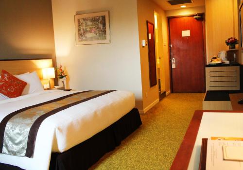 a hotel room with a large bed and a door at Summit Parkview Yangon in Yangon