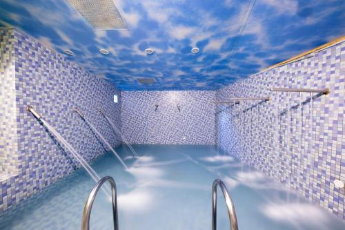 a blue tiled bathroom with a shower with a blue ceiling at Formosan Naruwan Garden Hotel in Taitung City