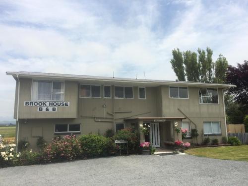 a large house with a sign that reads arrow house beeb at Brook House B&B & Cottages in Kaikoura