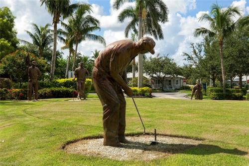 a statue of a man playing golf in a park at Vacation in Paradise in Lely Resort