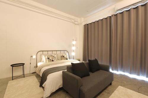 a bedroom with a bed and a couch and a chair at Loft Series by Pak-Up in Krabi town