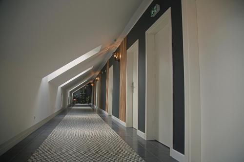 a corridor of a building with white walls and a white hallway at B&B ALIBI in Bardejov