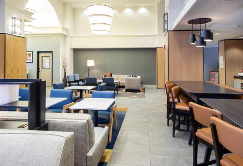 a dining room with tables and chairs and a chalkboard at Hyatt House Chicago Schaumburg in Schaumburg