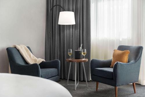 a room with two chairs and a table with wine glasses at La Quinta by Wyndham San Luis Obispo in San Luis Obispo