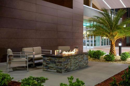 a lobby with a table and chairs and a palm tree at La Quinta Brunswick/Golden Isles in Brunswick