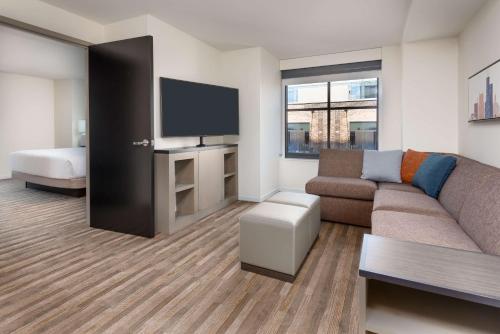 a living room filled with furniture and a tv at Hyatt House Chicago West Loop in Chicago