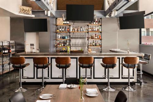 a bar in a restaurant with bar stools at La Quinta by Wyndham San Luis Obispo in San Luis Obispo