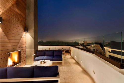 a balcony with two blue couches and a fireplace at La Quinta by Wyndham San Luis Obispo in San Luis Obispo