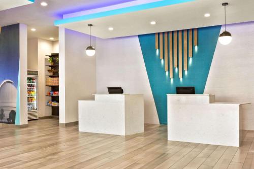 a lobby with two white desks and a colorful wall at La Quinta by Wyndham Richmond-Sugarland in Richmond