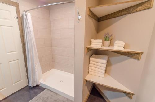 uma cabina de duche ao nível do chão na casa de banho com toalhas em Glacier Suites #1 em Palmer