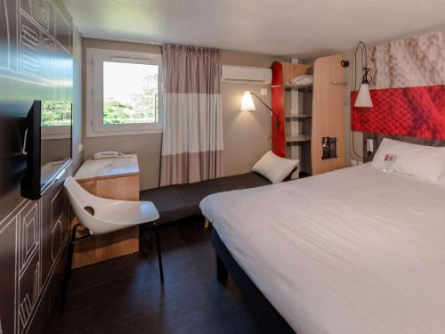 Habitación de hotel con cama grande y TV en IBIS Lyon Sud Chasse Sur Rhône, en Chasse-sur-Rhône