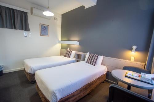 The Midcity Motor Lodge tesisinde bir odada yatak veya yataklar