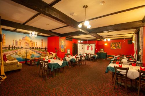 a restaurant with tables and chairs and a painting on the wall at The Midcity Motor Lodge in Orange