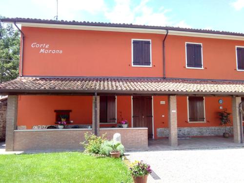 an orange building with a sign that reads gene morgan at CORTE MORONA in Marmirolo