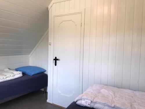 a room with a door and a bed in a room at Beverøya Hytteutleie og Camping in Bø