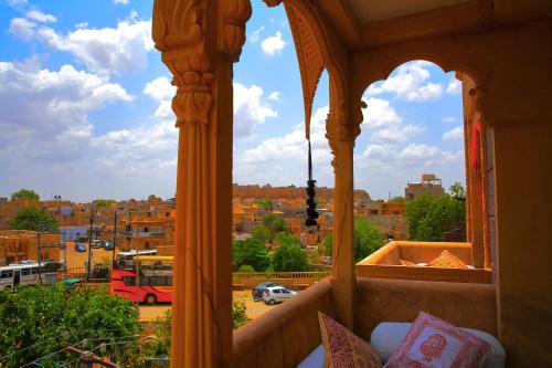 a balcony with a view of a city with a bus at The Wanderlust Guest House & Safari in Jaisalmer