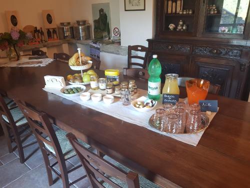 a wooden table with food and drinks on it at Agriturismo Fattoria didattica Il Macereto in Fivizzano