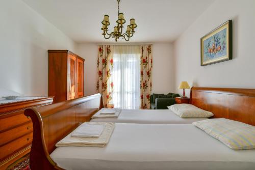 a bedroom with a large bed and a chandelier at Apartment Ruzica in Sveti Stefan