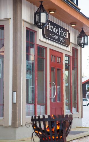 a bench in front of a store with a red door at Hovde Hotell in Vemdalsskalet