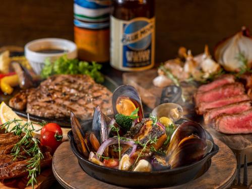 a table with a plate of food with seafood and meats at Hotel Mystays Kagoshima Tenmonkan in Kagoshima