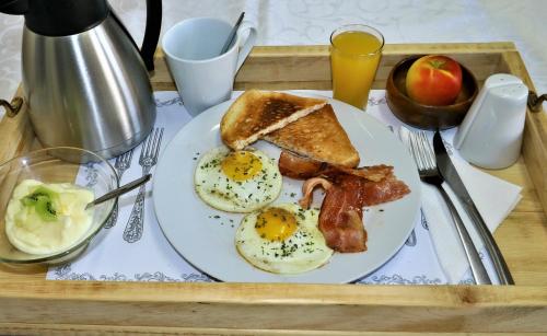 a tray of breakfast food with eggs bacon and toast at Tiende Laan Bed & Breakfast and Self-Catering in Walvis Bay
