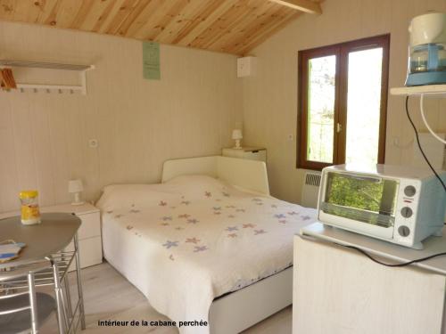 1 dormitorio pequeño con 1 cama y TV en domaine de Couchenoire en Joux-la-Ville