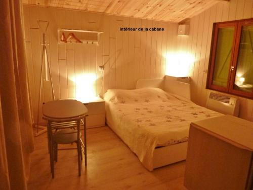 um pequeno quarto com uma cama e um banco e duas luzes em domaine de Couchenoire em Joux-la-Ville