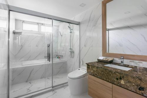 a bathroom with a shower and a toilet and a sink at Adelphi Grande Sukhumvit in Bangkok