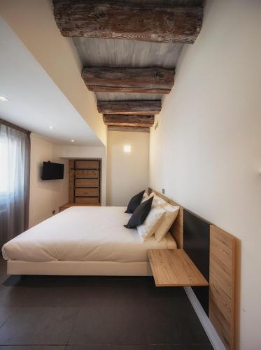 a bedroom with a large bed with a wooden bench at Le Palme Rooms & Breakfast in Trento