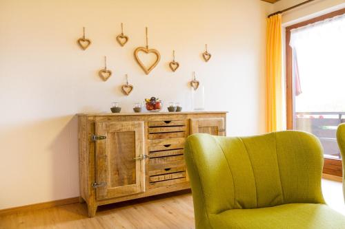 a green chair and a cabinet in a room at Ferienwohnungen Alpentraum - Landhaus Schmetterling in Oberstdorf