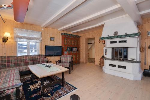 a living room with a couch and a fireplace at Dale Gård in Heggenes