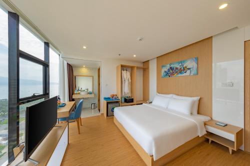 1 dormitorio con 1 cama blanca grande y escritorio en KOVA Diamond Hotel Da Nang, en Da Nang