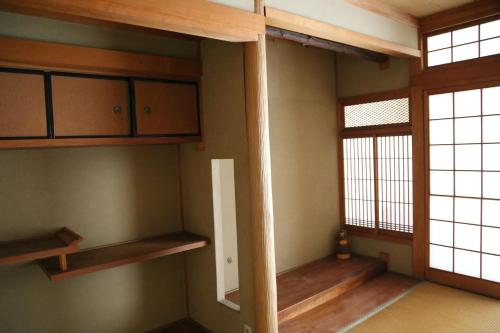 a room with wooden shelves and a window at PERCH GUEST HOUSE in Tatsuno