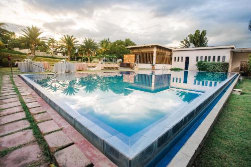 a swimming pool with blue water in a yard at The Park - Silang in Silang