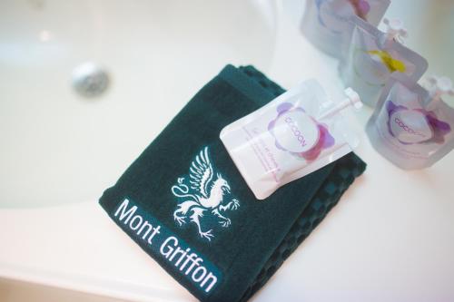 une serviette verte avec une brosse à dents et une boîte de dentifrice dans l'établissement Golf Hotel de Mont Griffon, à Luzarches