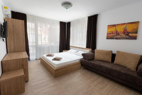 a living room with a bed and a couch at Tiffany Boutique Suits - Pomorie in Pomorie