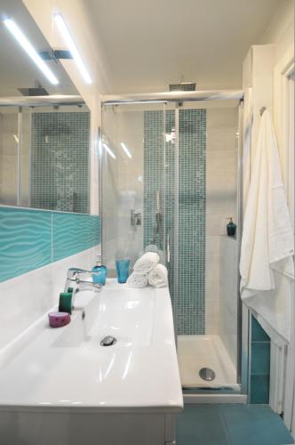 a white bathroom with a sink and a shower at Casa Sassolini in Naples