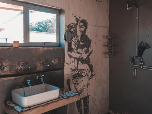 a bathroom with a sink and a painting on the wall at The Prawn Hatchery Pty Ltd on Amatikulu in Dokodweni