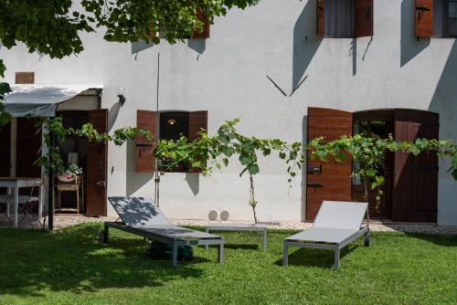 two chairs and a table in front of a building at Regina nel cuore del Veneto in Codognè