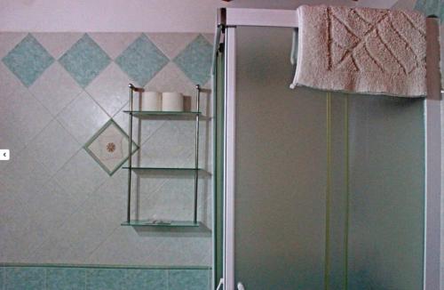 a bathroom with a shower with a towel hanging on a wall at B&B Triskèles in Siracusa