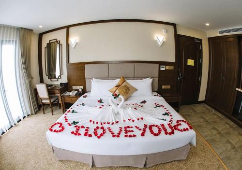 a bed in a hotel room with a happy anniversary sign on it at Duc Huy Grand Hotel in Lao Cai