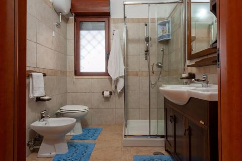 Un baño con inodoro, lavabo y ducha. en Villa Chloe, en Santa Luria