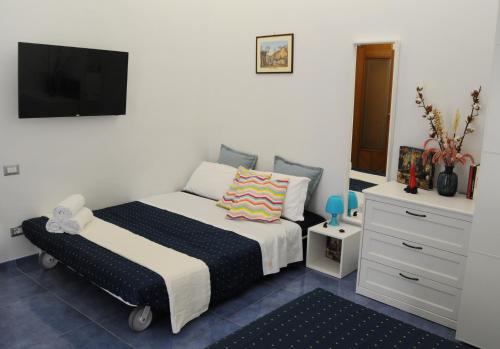 a bedroom with two beds and a flat screen tv at Casa Sassolini in Naples
