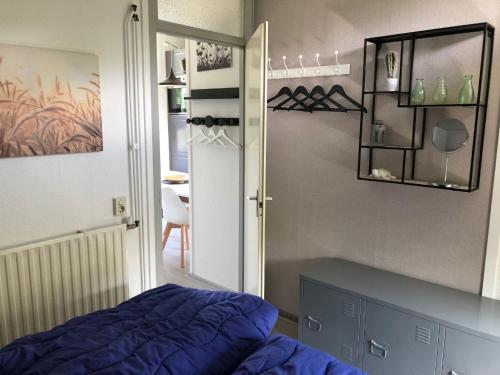 1 dormitorio con cama, espejo y puerta en Hygge House 10 en Andijk