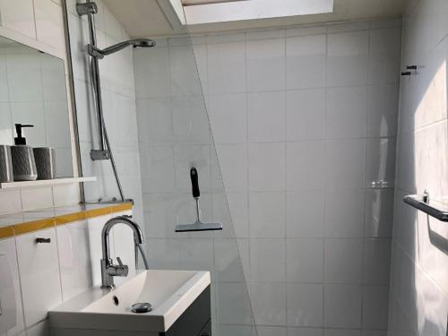 een witte badkamer met een wastafel en een douche bij Hygge House 10 in Andijk